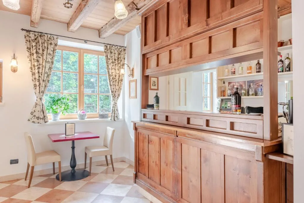 Angolo bar in legno con tavolino e finestra affacciata sul verde