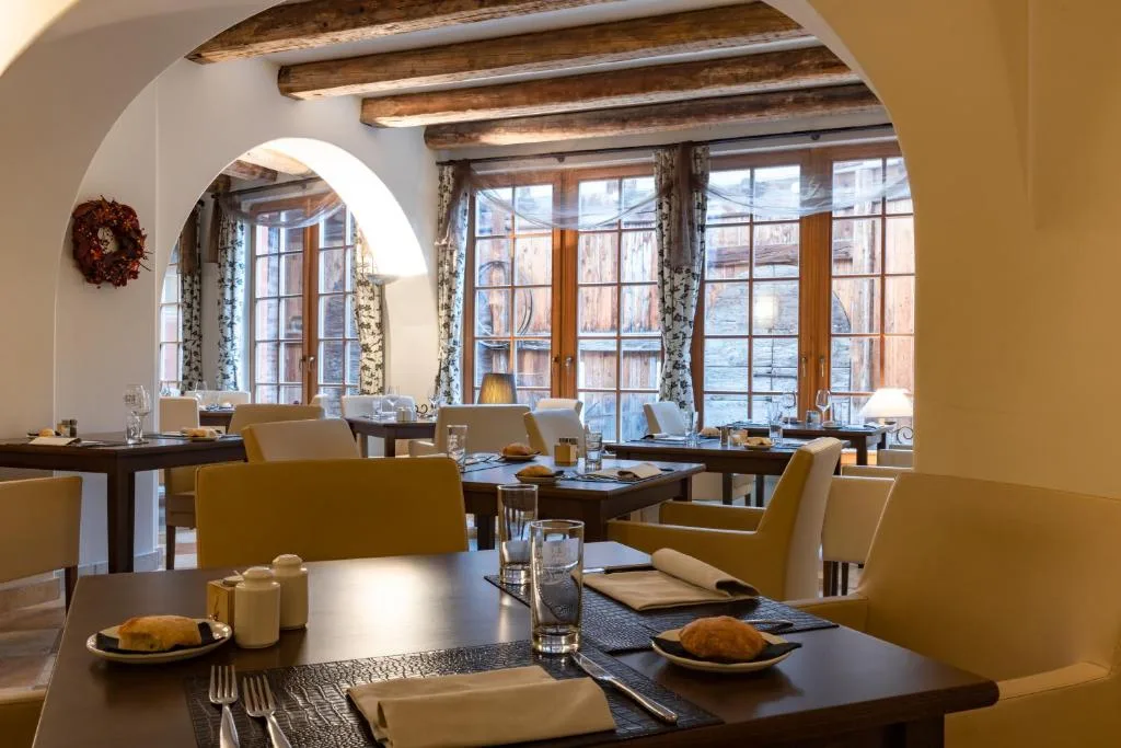 Tavoli apparecchiati nella sala ristorante con travi in legno