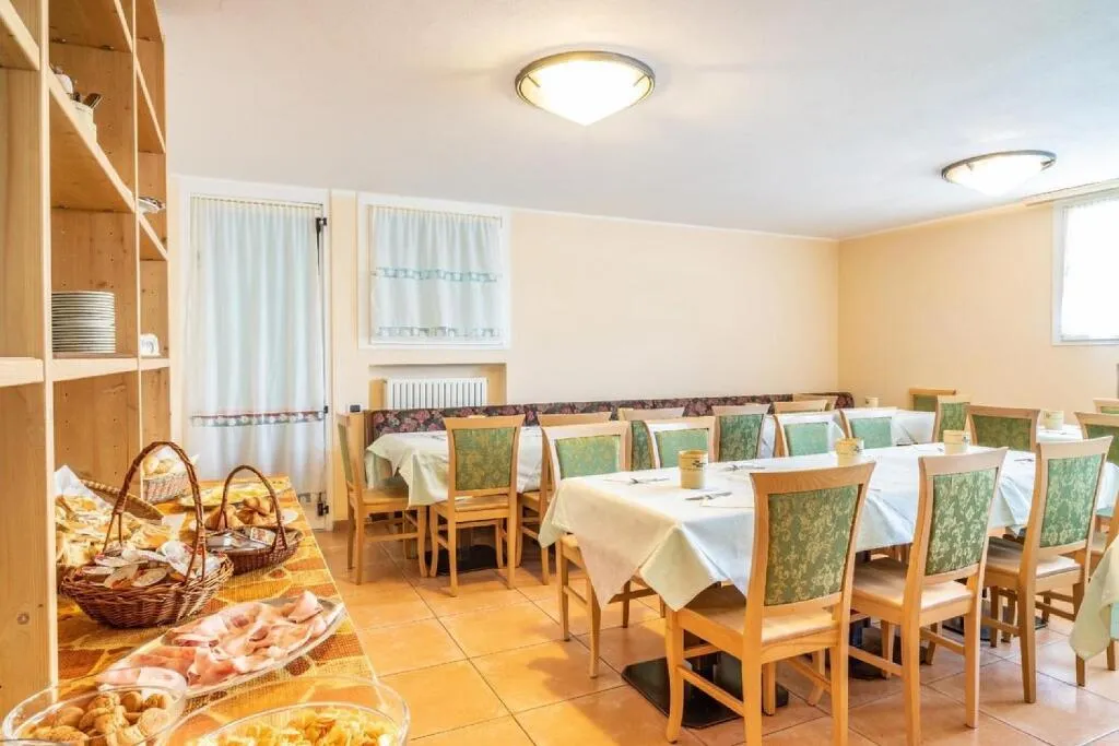 Sala colazione con tavoli apparecchiati e buffet di prodotti freschi