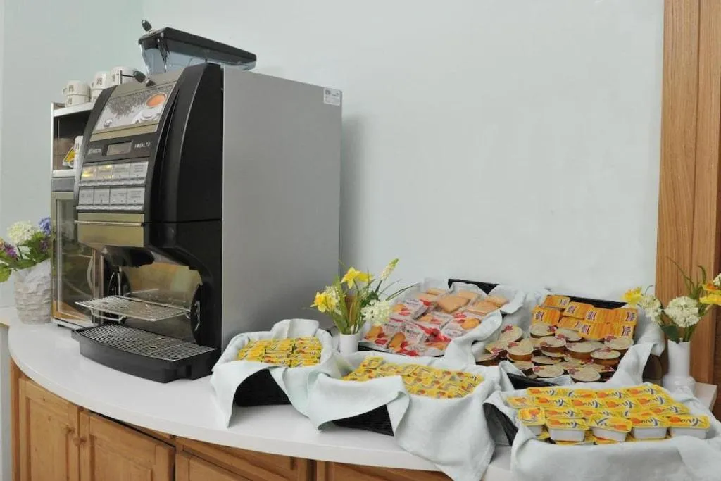Angolo colazione con macchina del caffè e buffet di marmellate e yogurt