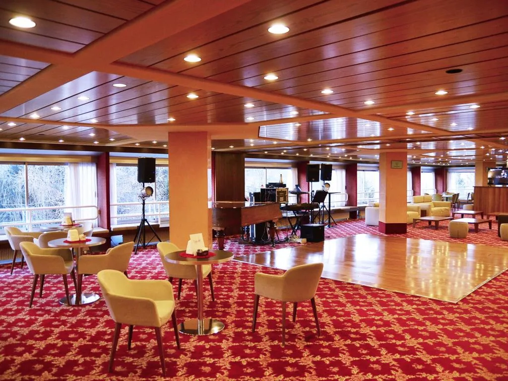 Sala da ballo con pista in legno, tavolini e strumenti musicali