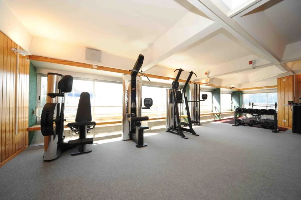Palestra attrezzata con macchinari fitness e ampie finestre luminose