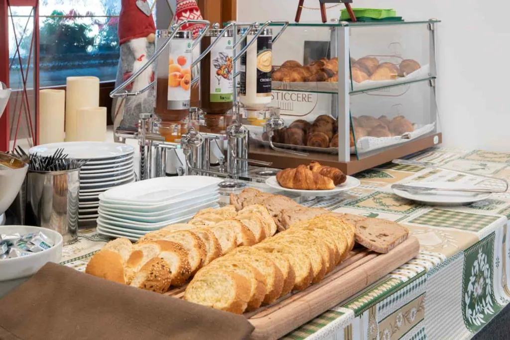 Buffet colazione con pane affettato, croissant, marmellate e cornetti