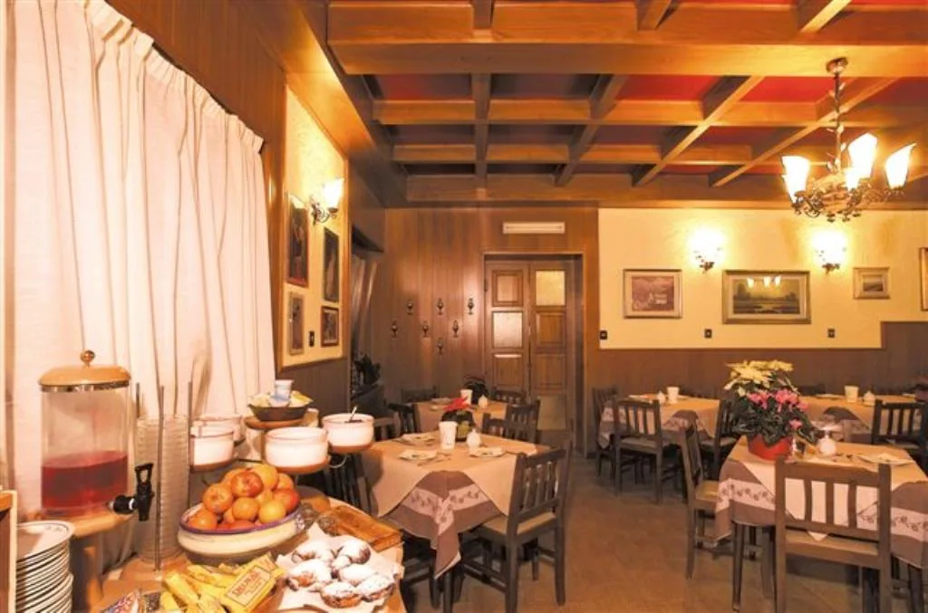 Sala colazione con soffitto a cassettoni in legno, buffet e tavoli apparecchiati
