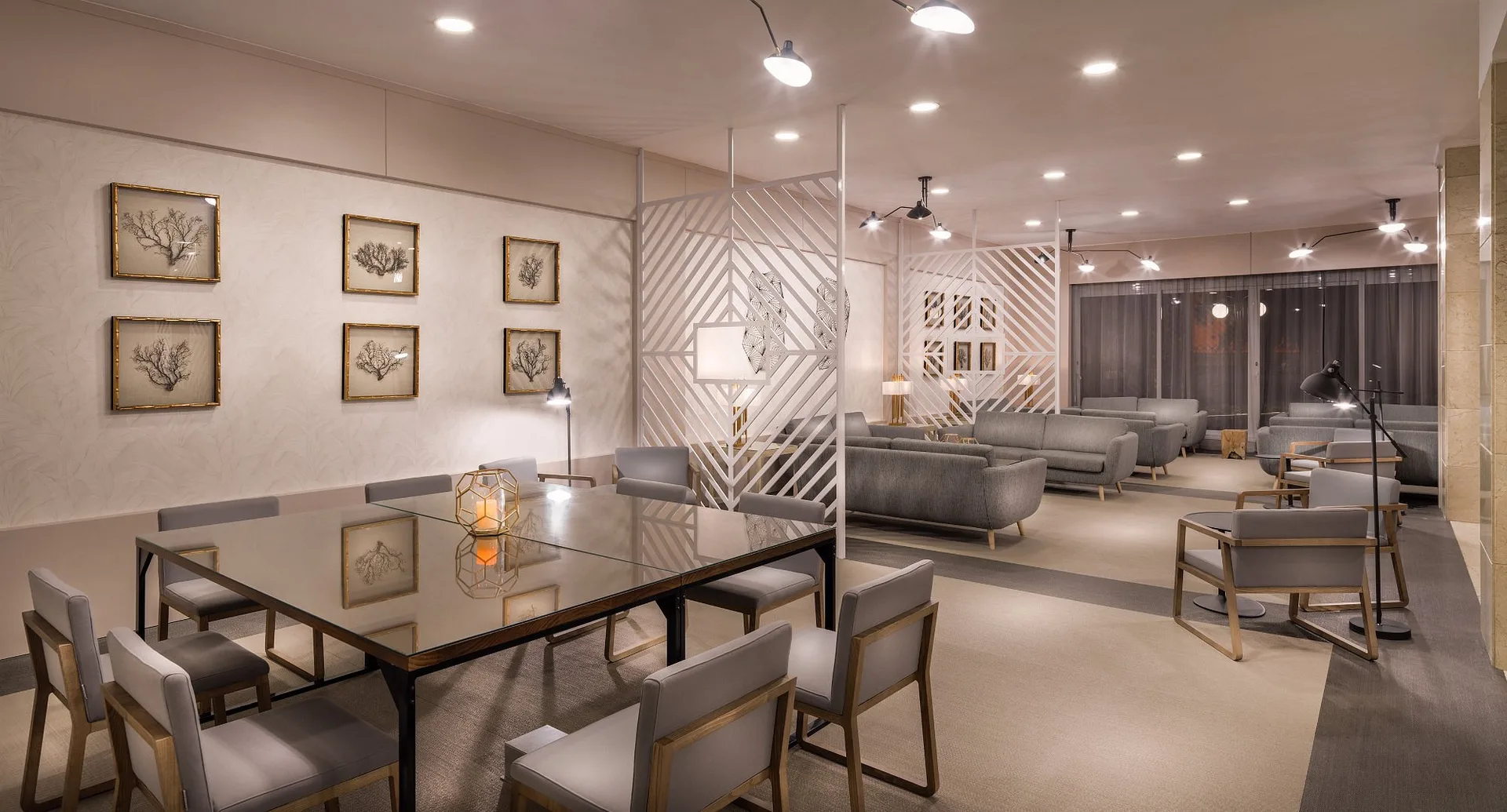Elegante area lounge interna con divani grigi, tavolo e decorazioni alle pareti